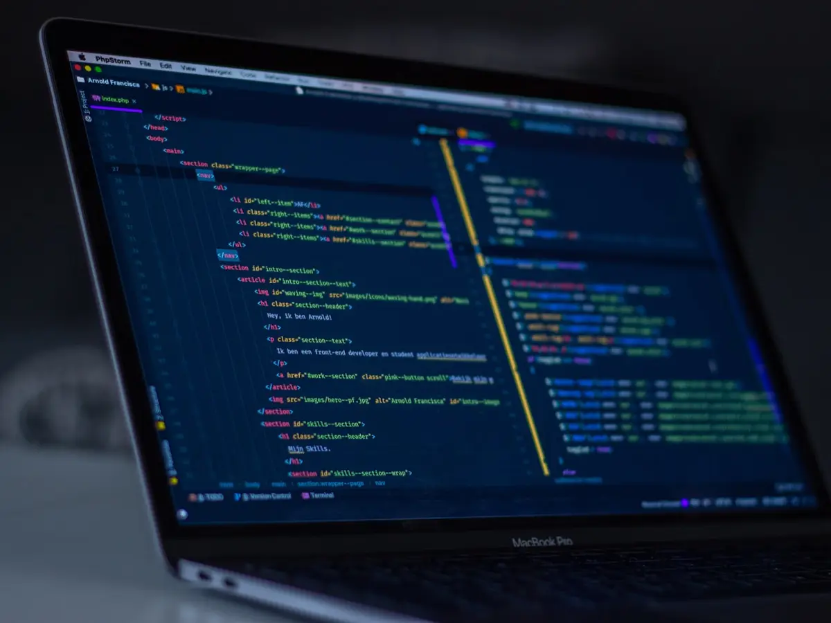 Lignes de code sur écran sombre — maintenance logicielle pilotée par IA